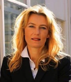 Porträt einer Frau mit blonden Haaren in einem professionellen Business-Outfit, fotografiert vor einem Fenster. Perfekt für eine Webseite über professionelles Webdesign in Wien.
