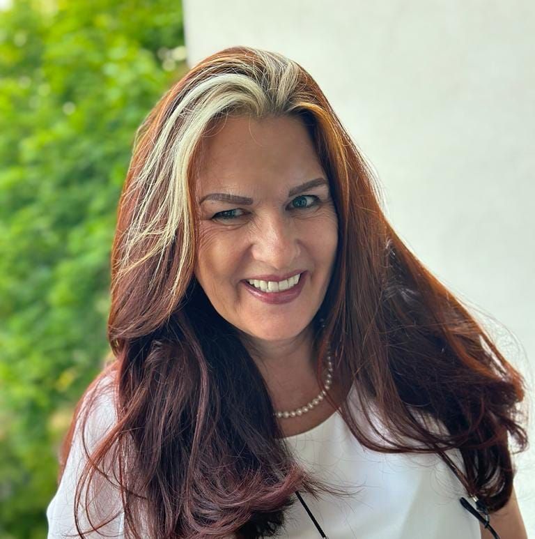Porträtaufnahme einer lächelnden Frau mit langen braunen Haaren mit blonden Strähnen in Wien, geeignet für professionelles Webdesign und Homepage-Erstellung